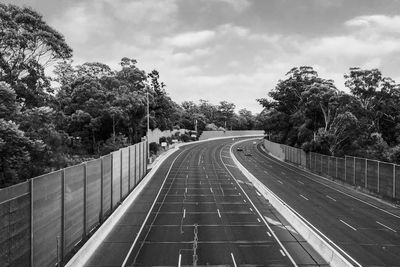 Road leading towards city against sky