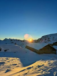 Scenic view of snow covered landscape against clear blue sky