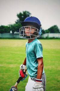 Rear view of boy standing on field