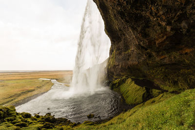 Scenic view of waterfall against sky