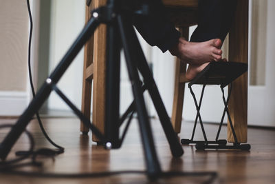 Low section of man sitting on chair at home