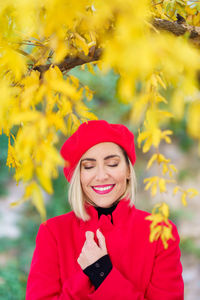 Smiling woman against yellow leaves on trees