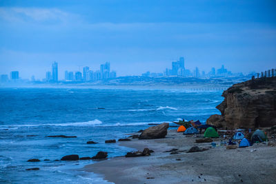 Scenic view of sea by buildings against sky