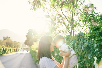 Couple kissing against trees