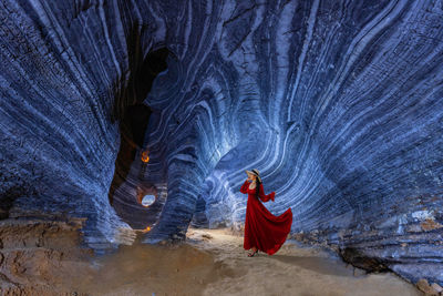 Full length of woman standing in illuminated cave