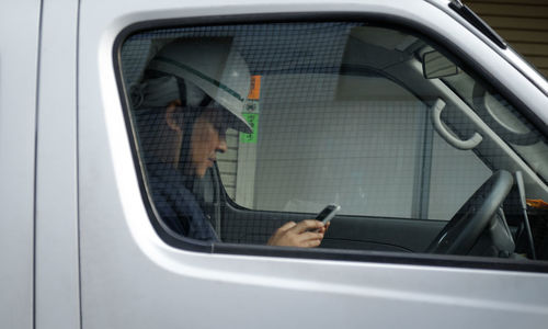 Portrait of man holding car window