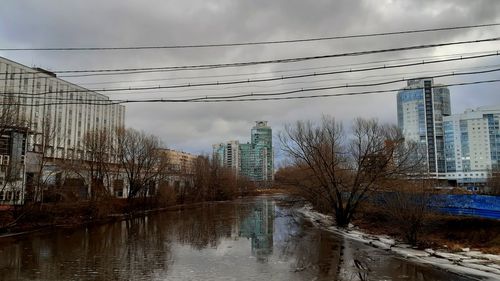 Canal amidst buildings against sky