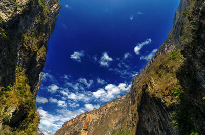 Scenic view of rocky mountains against blue sky