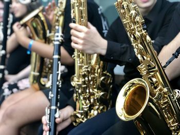 Midsection of people playing saxophone at music concert