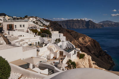 Buildings by sea against sky