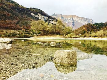 Scenic view of lake by mountains against sky