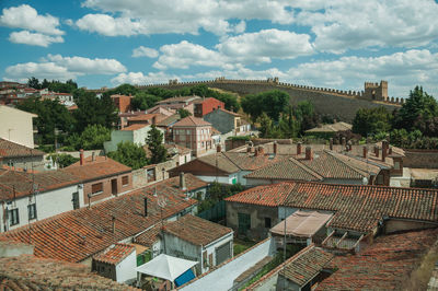 Cityscape with alleys among old houses rooftops and stone wall around the town in avila, spain.
