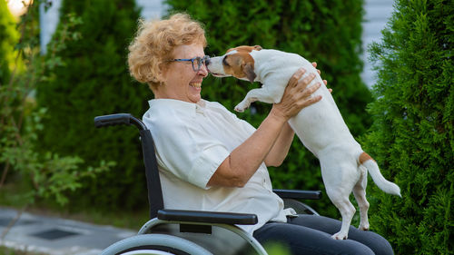 Side view of woman with dog sitting on road