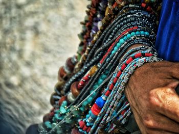 Cropped hand of man holding bead necklaces