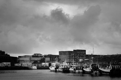 Boats in harbor against buildings in city