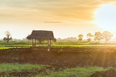 Gazebo on field against sky during sunset