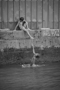 Full length of young woman sitting in swimming pool