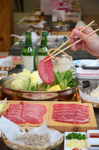 Cropped hand of woman having food on table