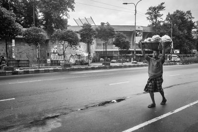 Full length rear view of man walking on road