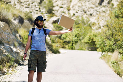 Man hitchhiking on country road