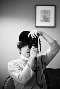 Portrait of boy photographing against wall