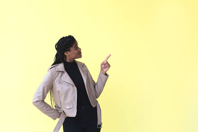 Full length of young woman standing against gray background