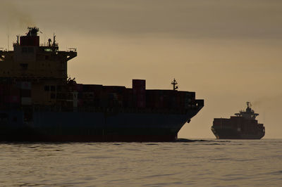 Ship sailing on sea against sky during sunset