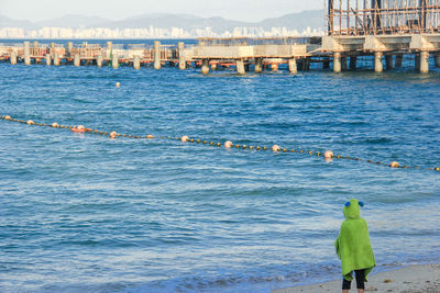 Rear view of man in sea against sky