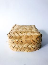 Close-up of wicker basket on table against white background