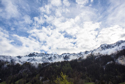 Low angle view of snowcapped mountains against sky