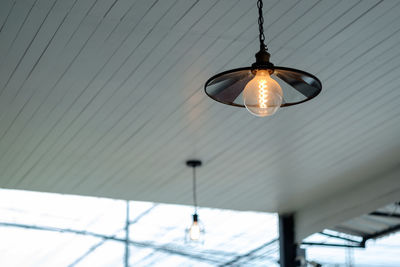 Low angle view of light bulb hanging on ceiling