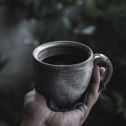 Close-up of hand holding coffee cup