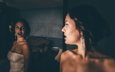 Young woman looking at her reflection in mirror