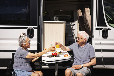 Senior couple sitting in front of trailer