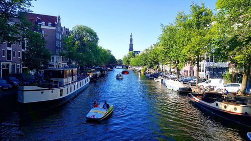 Boats in canal amidst buildings in city