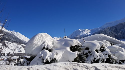 Panoramic view of snowcapped mountains against clear blue sky