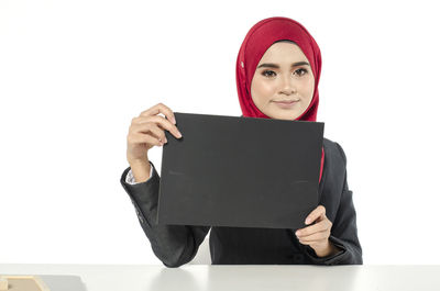 Portrait of a smiling young woman against white background