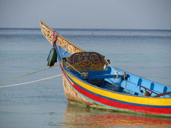 Boat moored on sea against sky