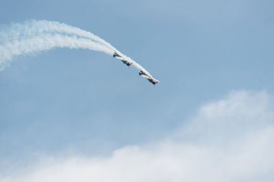 Low angle view of airplane flying against blue sky