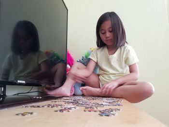 Girl playing jigsaw puzzle at home