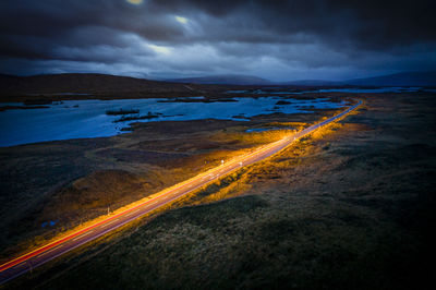 Aerial view of light trails on road against sky at night