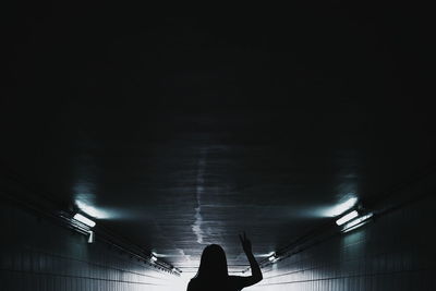 Woman in illuminated tunnel