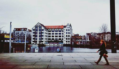 People walking in city against sky