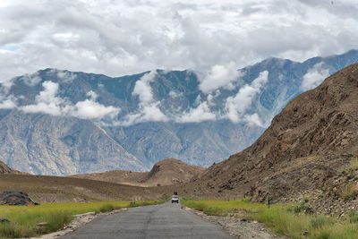 Road amidst mountains against sky