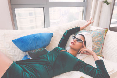 Midsection of young woman lying on sunglasses