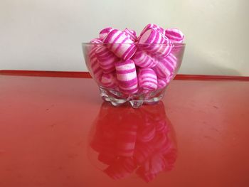 High angle view of pink petals on table against wall
