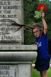 Girl holding flower at cemetery