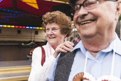 Portrait of senior woman having fun together with her husband on fair