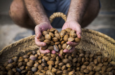 Close-up of man holding almonds in shell