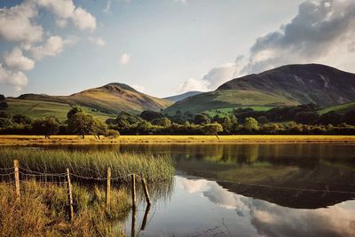 Scenic view of lake by mountains against sky